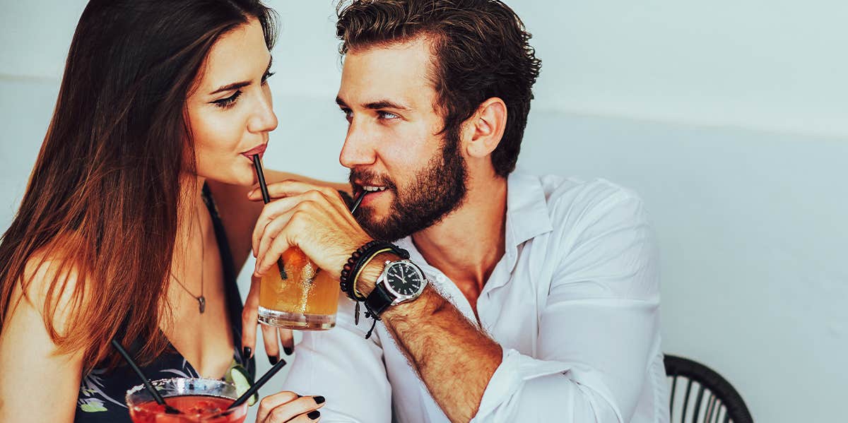 man and woman sharing drink