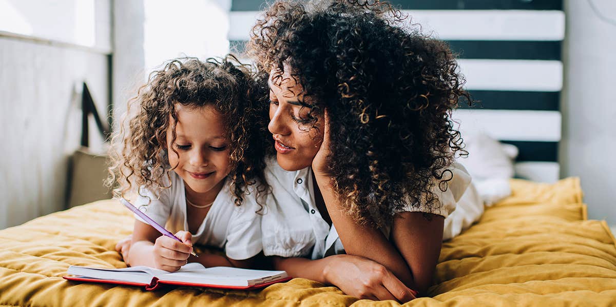 mom and daughter writing in book