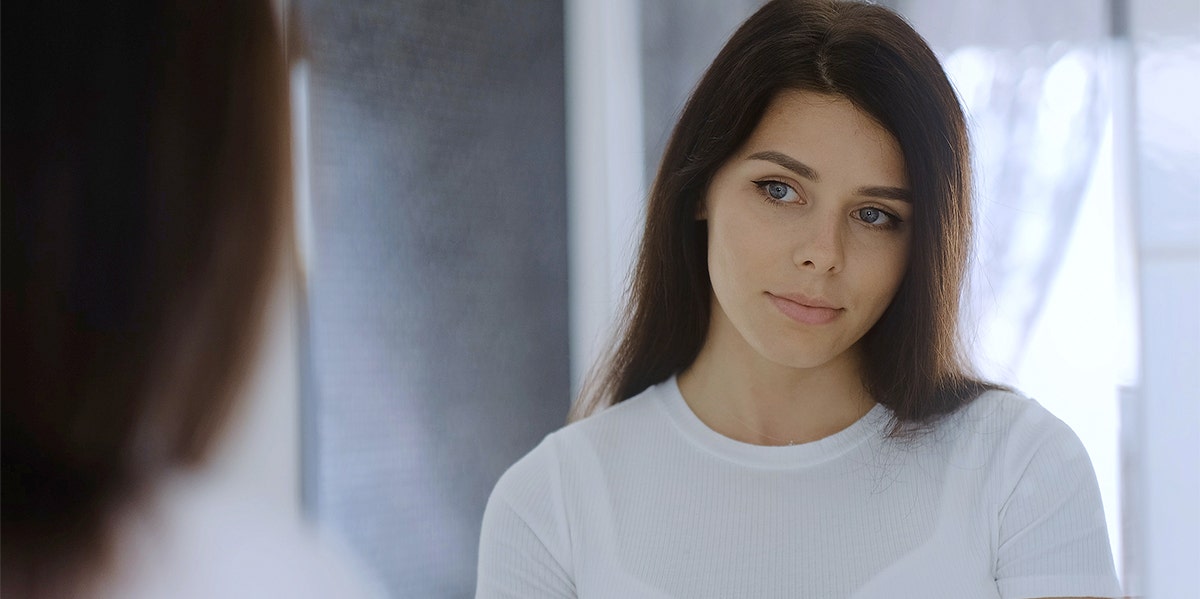 woman looking in mirror