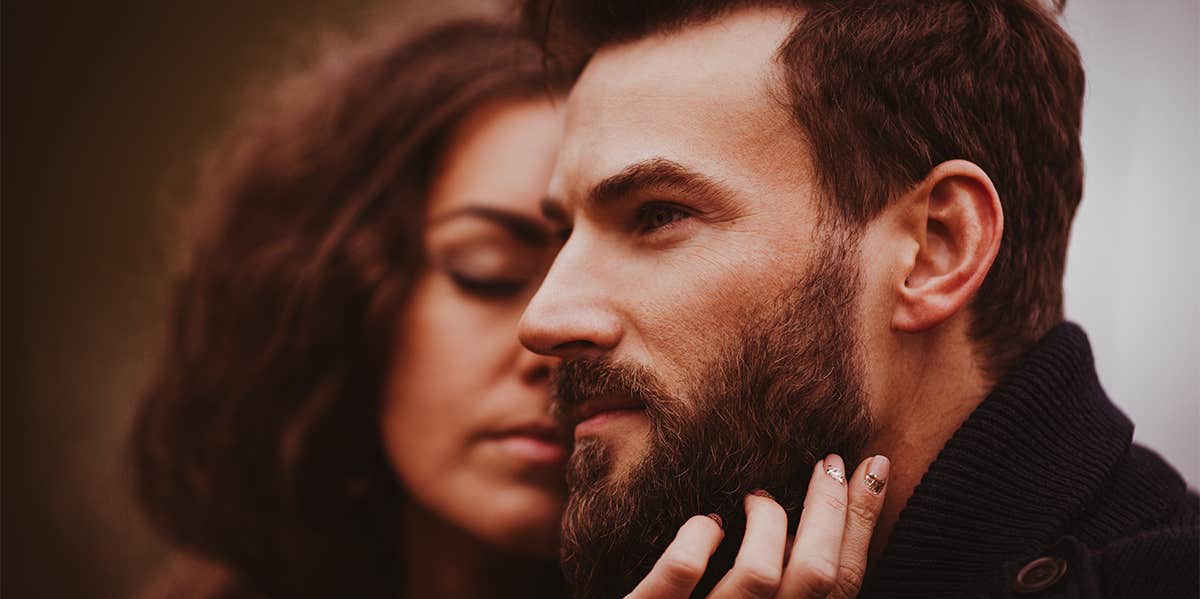 woman caressing man's beard