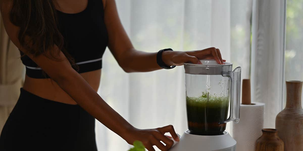 woman making green smoothie