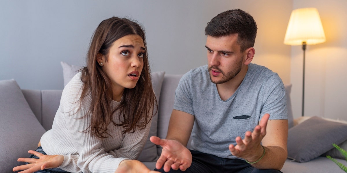 What Stonewalling Looks Like In A Relationship man and woman sitting on couch arguing