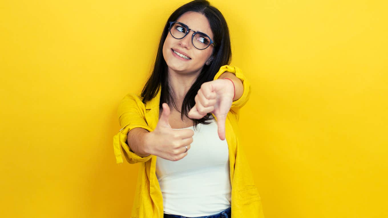 young brunette woman with thumbs up and thumbs down