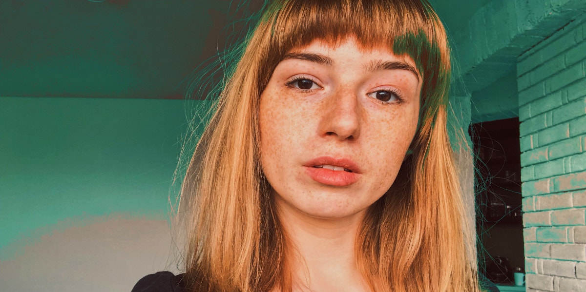 stern woman with bangs and green background