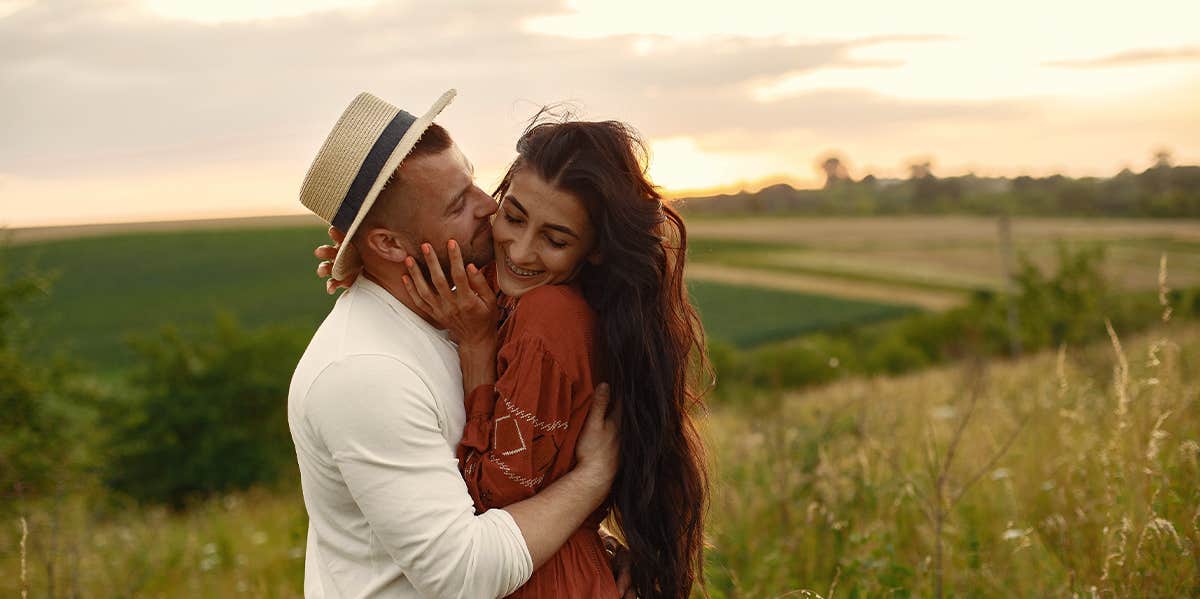 couple hugging in a field 