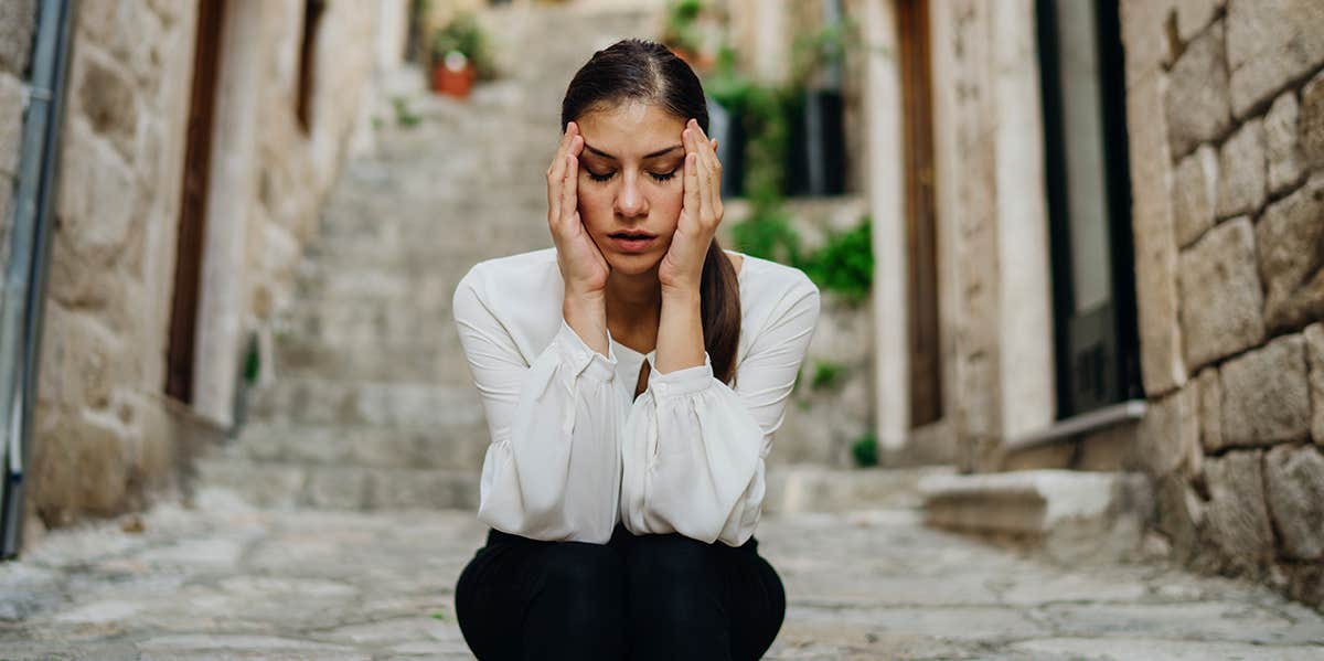 woman sitting on stairs overthinking