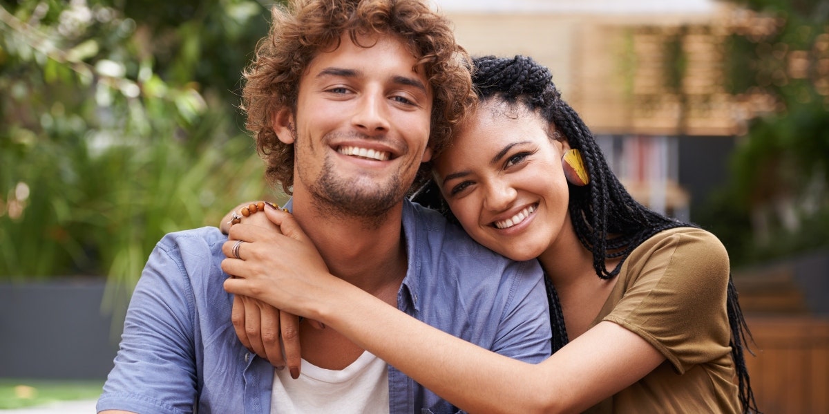 smiling woman hugging smiling man