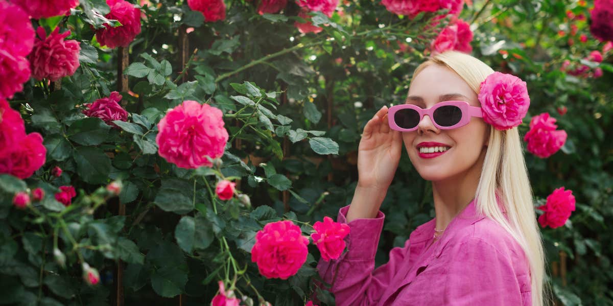woman next flower bush in sunglasses