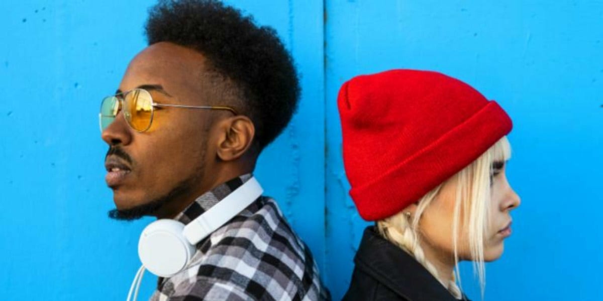 guy and girl facing away from each other blue background