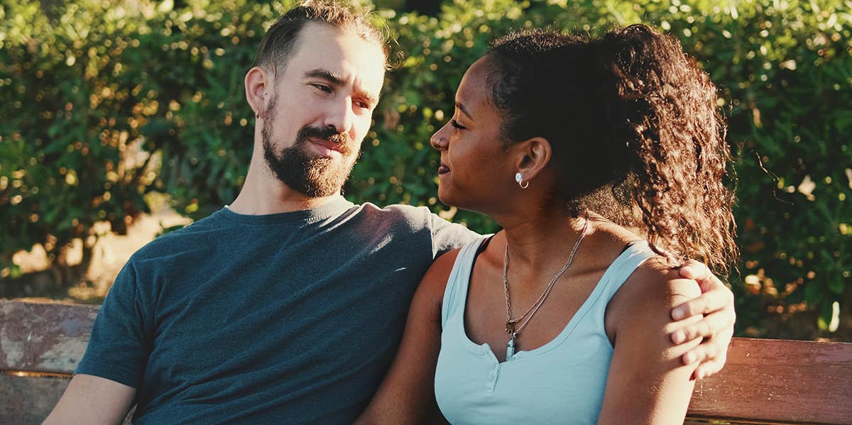 interracial couple sitting on bench