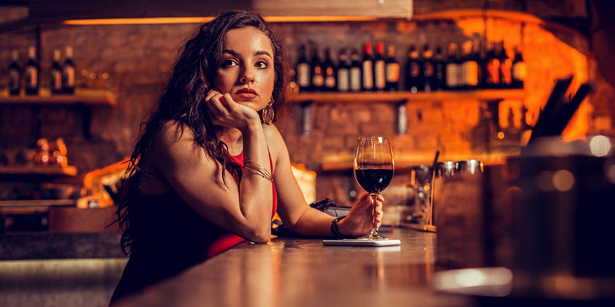 single woman sitting alone at bar