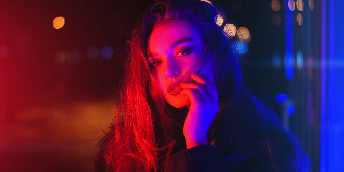 woman posing near neon lights at night