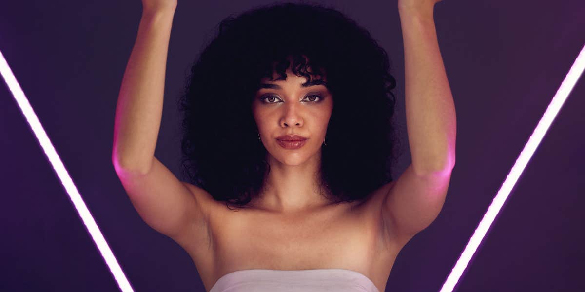 What Being Stuck In A "Love Triangle" Says About His Feelings For You woman with afro holding a neon light