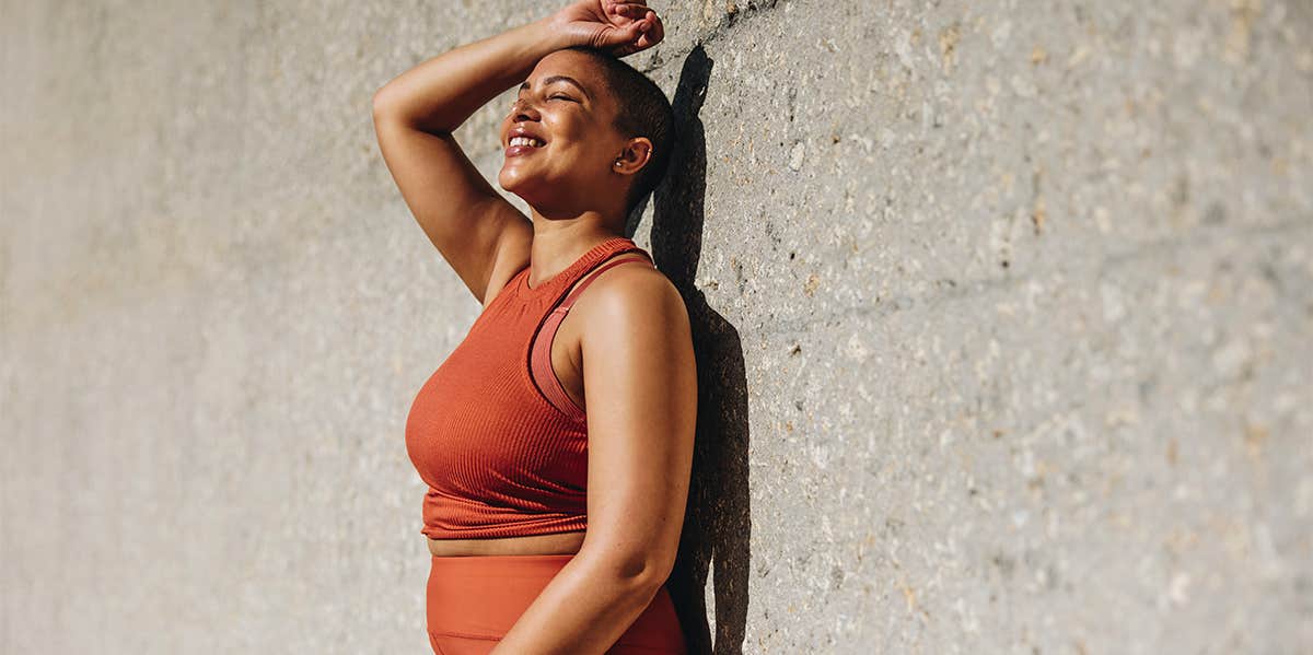 happy woman posing by wall