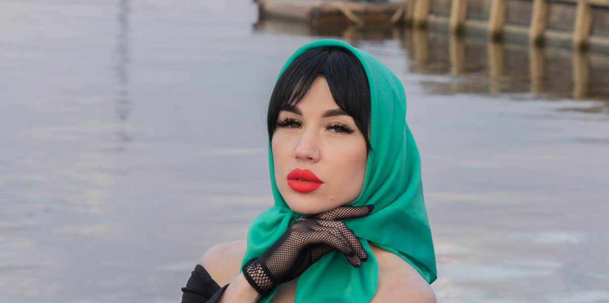 woman in green headscarf pouting