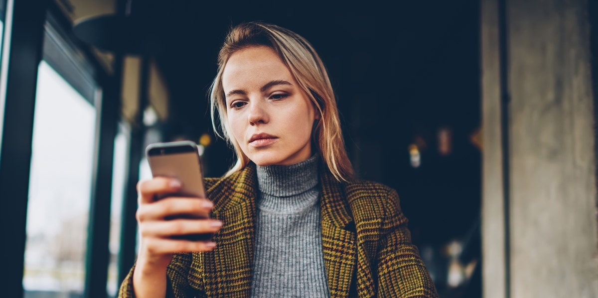 sad woman looking at cell phone