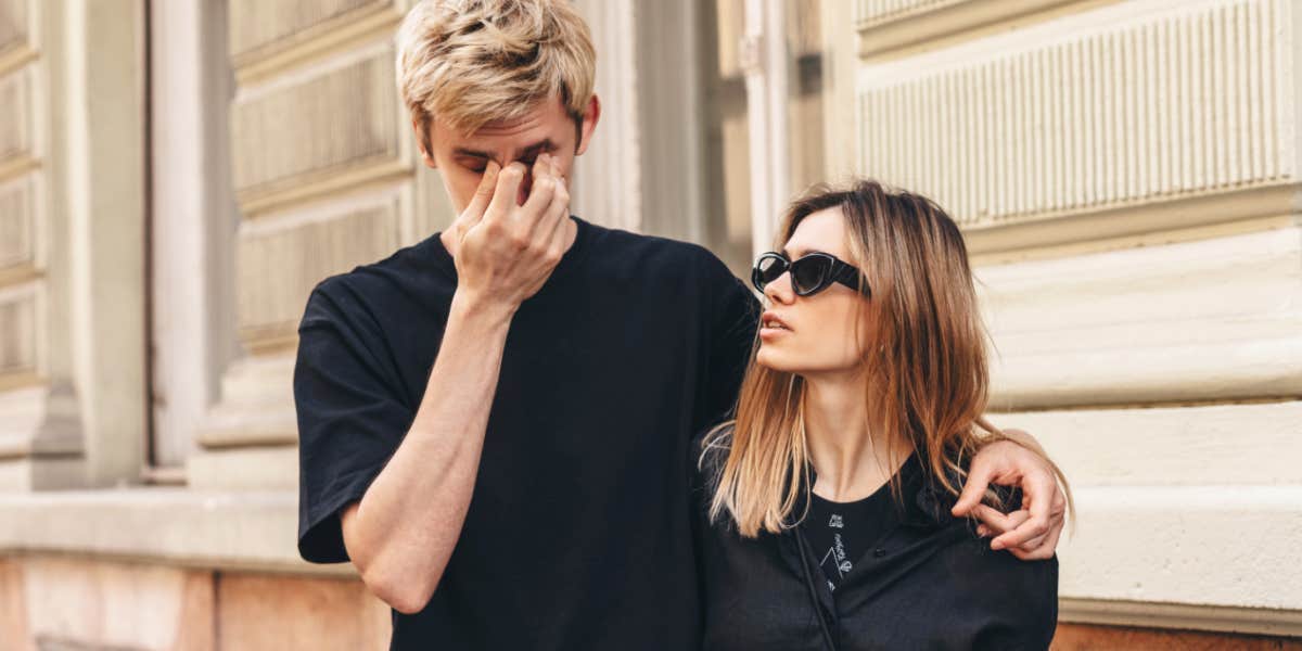 Couple walking down the road, man looking very upset