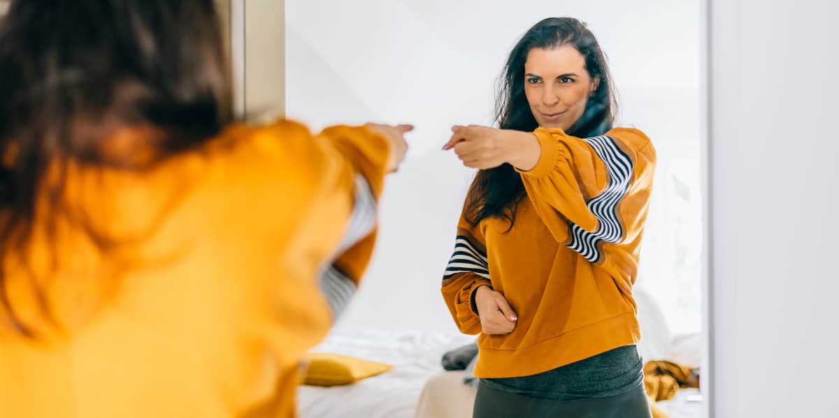 Is Talking To Yourself A Sign Of Intelligence? 5 Reasons People Who Talk To Themselves Are Smart Woman pointing at herself in mirror
