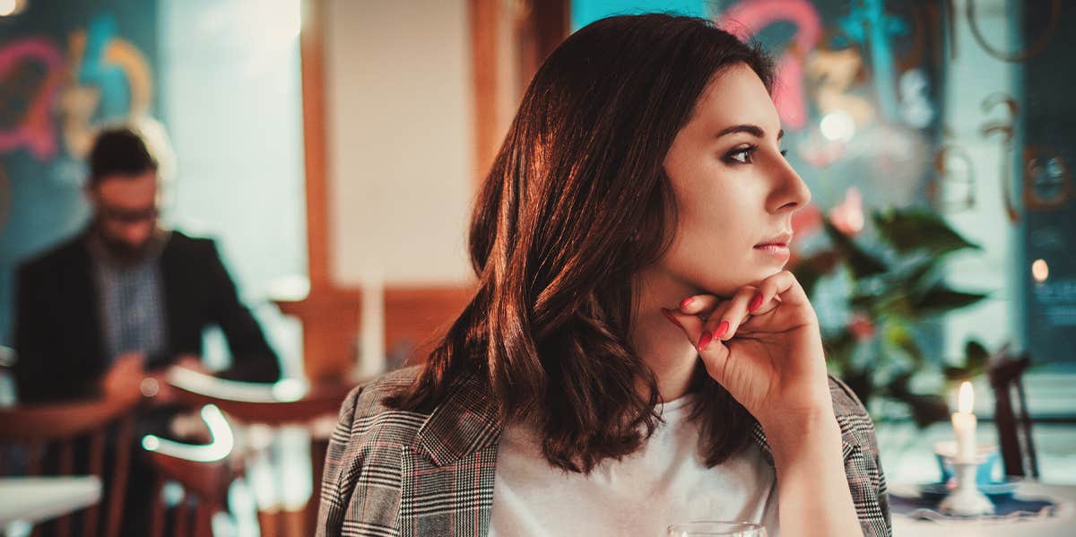 woman sitting at restaurant looking forlorn