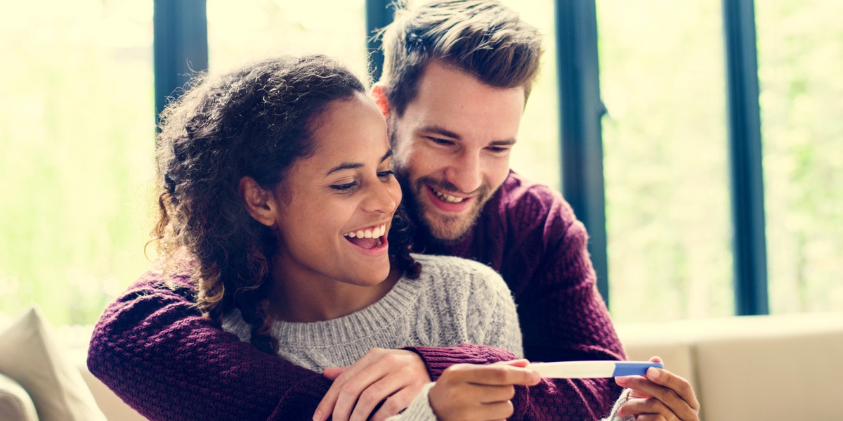 man and woman holding pregnancy test