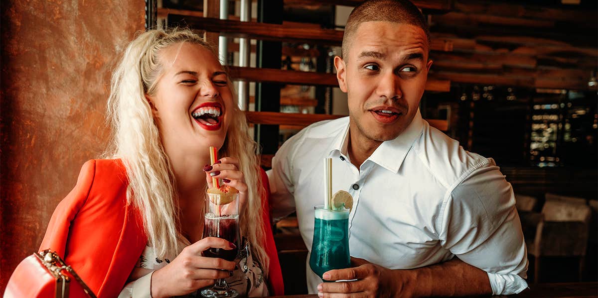 man and woman enjoying cocktails on date