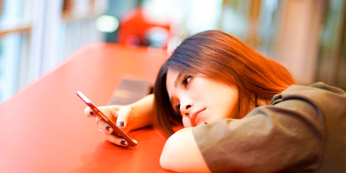 woman looking at her phone waiting for a guy to call