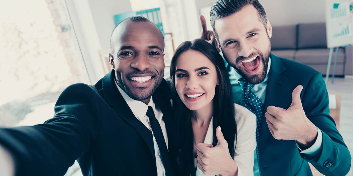 work frenemies smiling for camera selfie