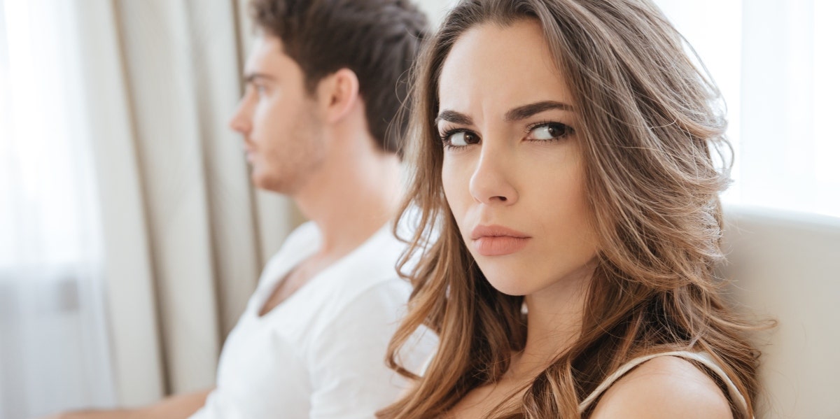 angry woman sitting next to distant man