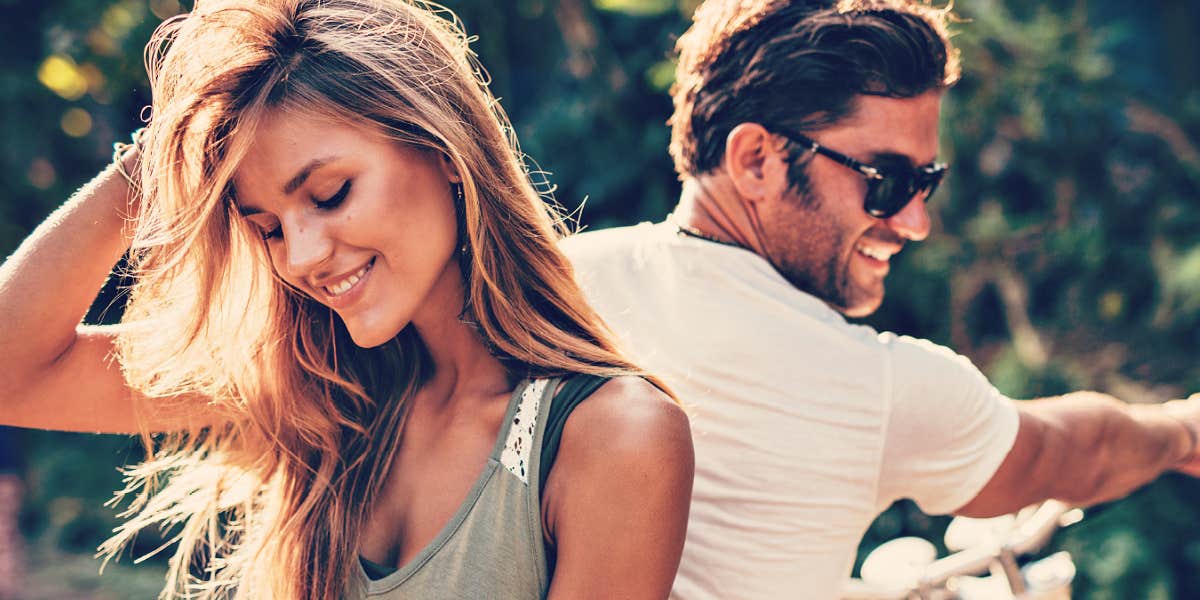 couple facing away from one another, smiling, outdoors