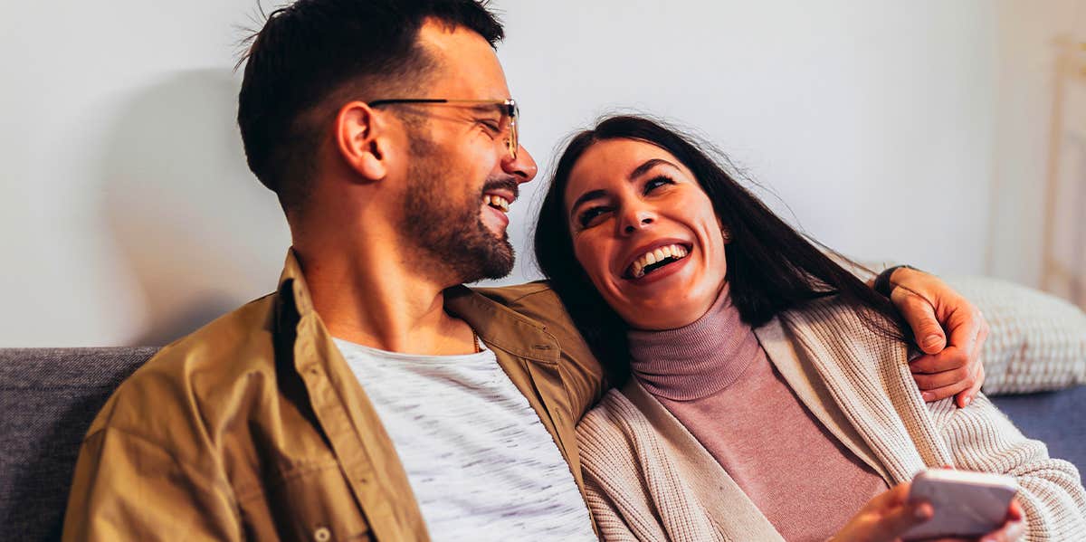 man and woman talking on couch