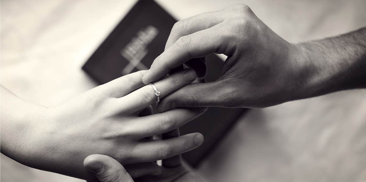 man putting ring on wife's finger