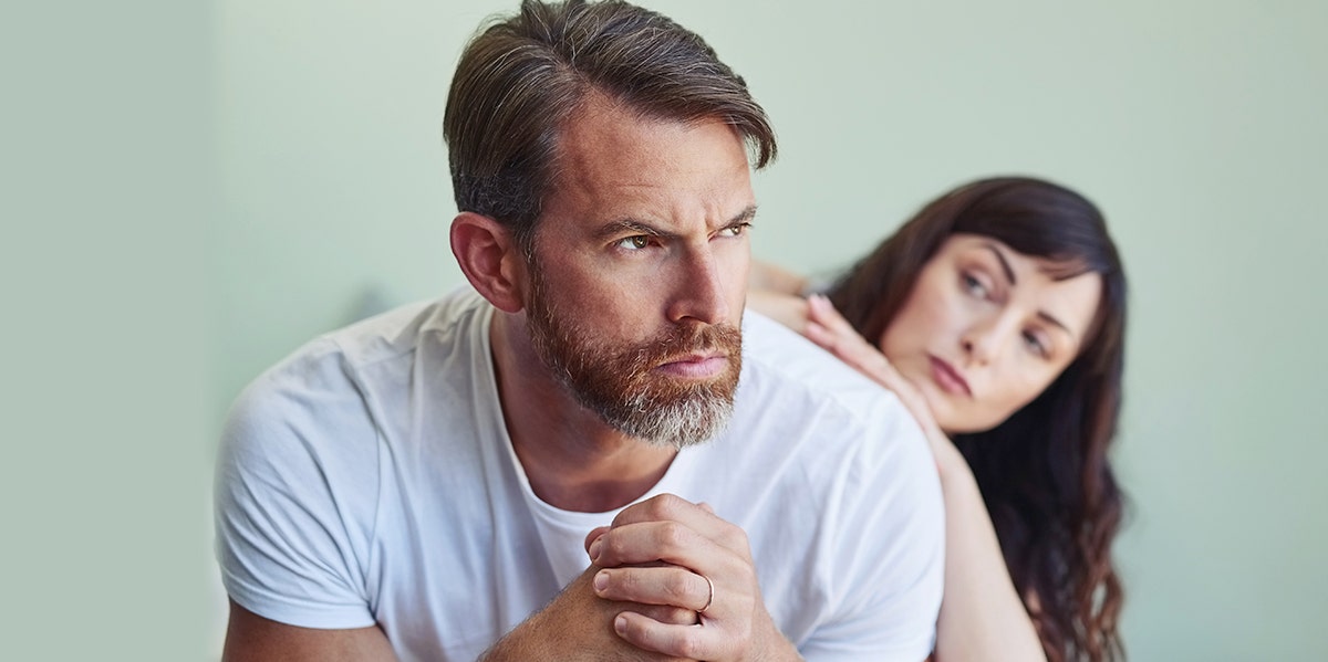 man sitting sternly woman behind him