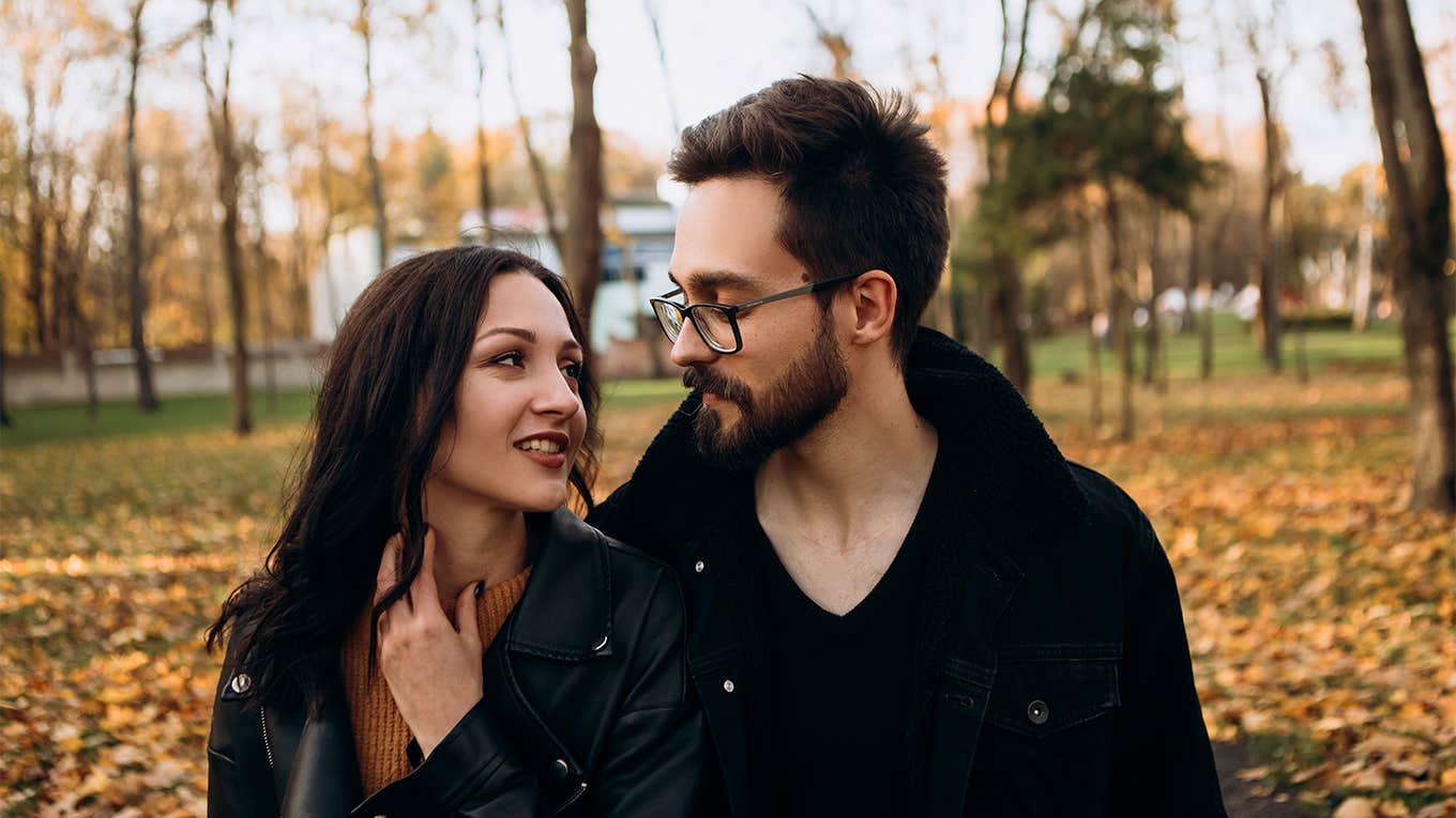 man and woman walking together in park