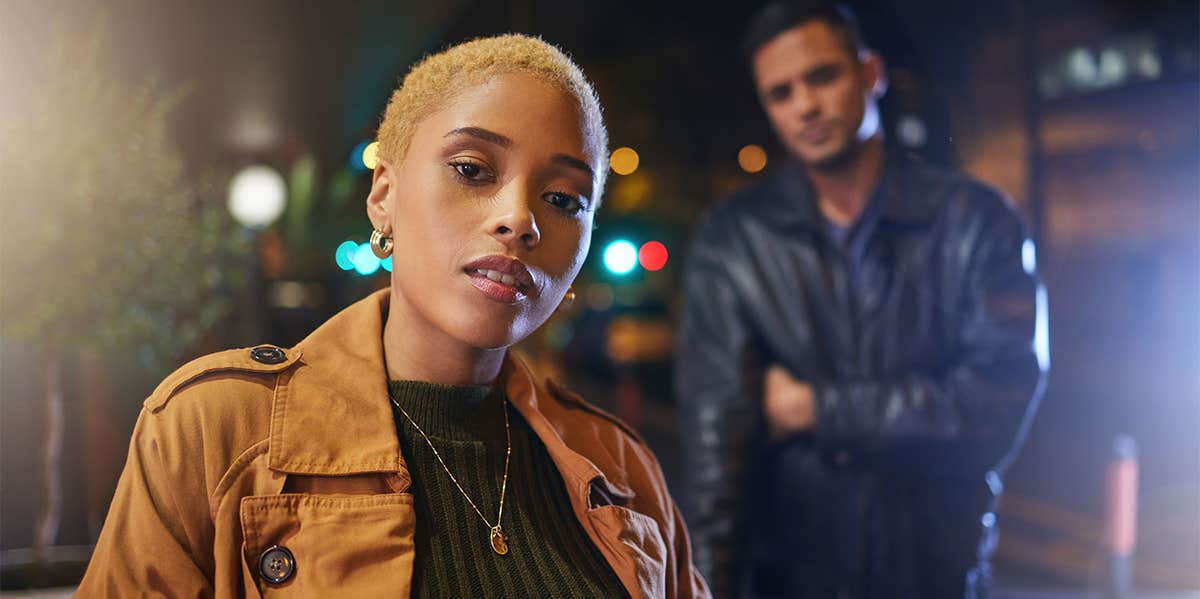 8 Reasons Men Lose Interest And Fall Out Of Love With Women woman with man standing behind her crossing his arms