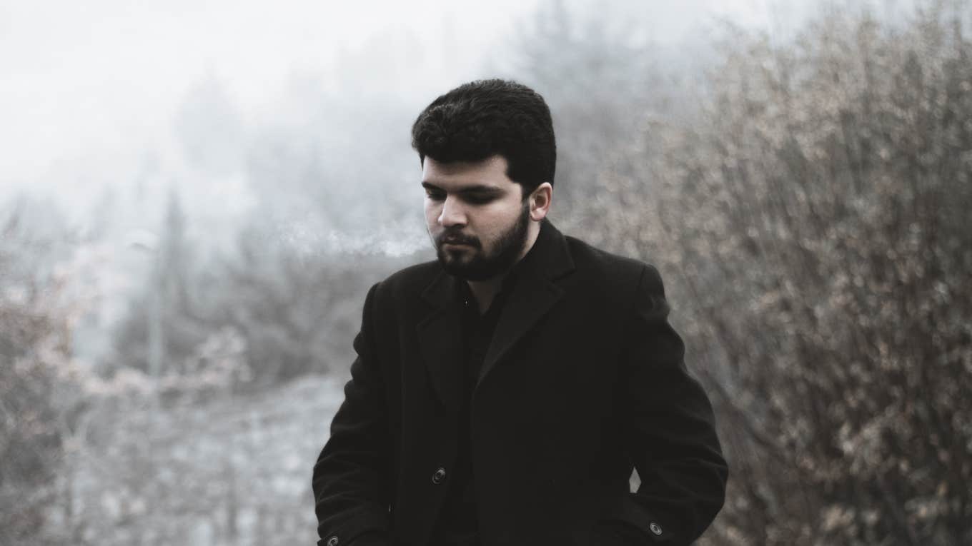 man standing alone in dark coat