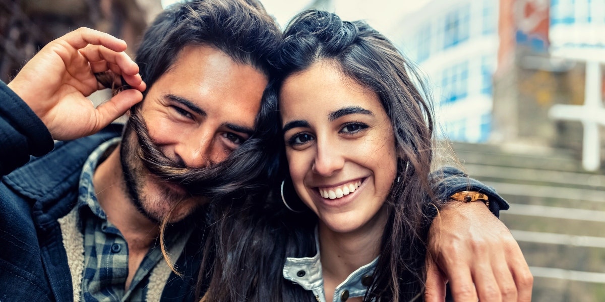 Man making moustache out of woman's hair