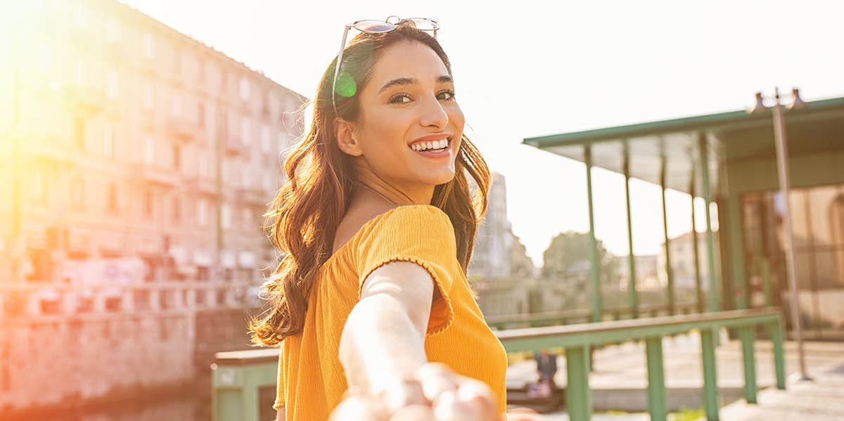 woman holding hand and walking