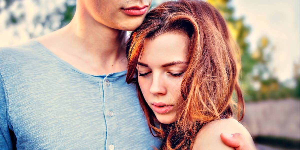 woman sadly nestled into man's chest