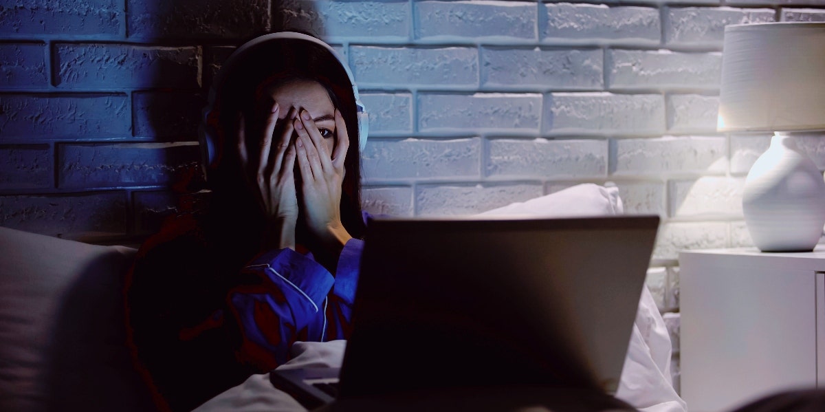 scared woman watching movie on laptop