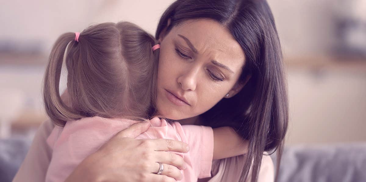 woman hugging a child, looking nervous