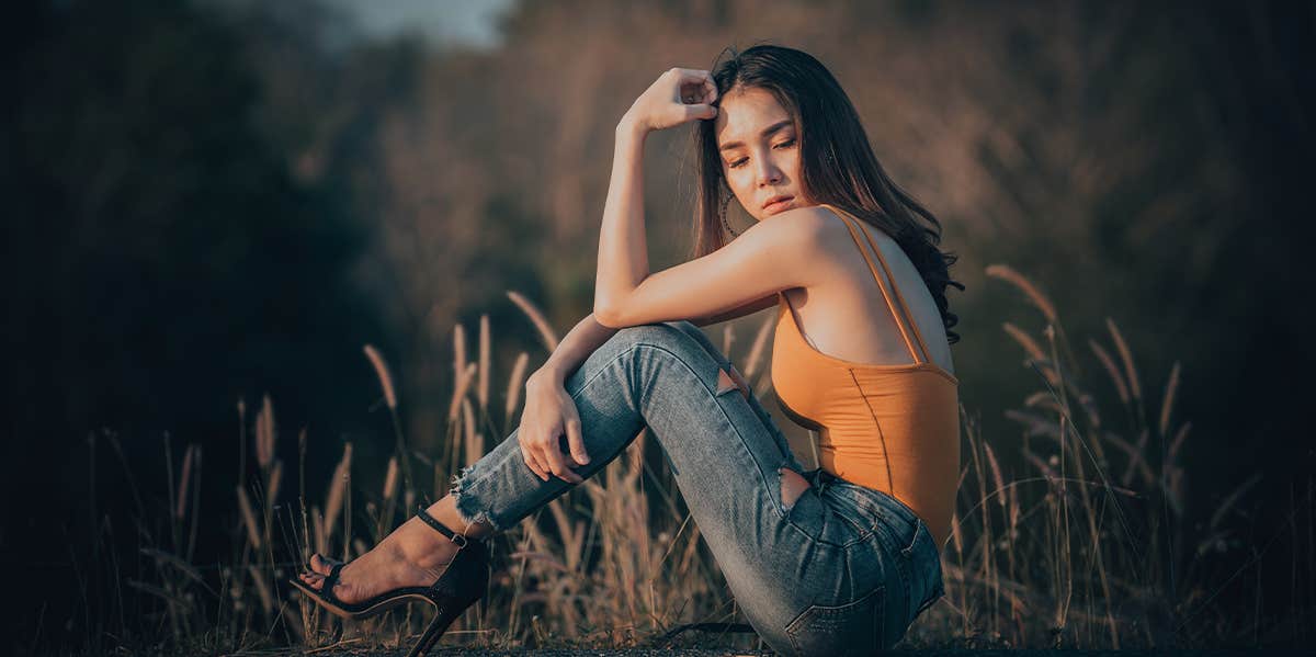 woman sitting alone in field