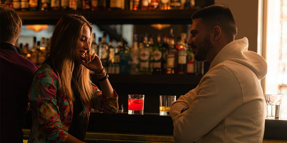 Why You Need To Stop Overthinking And Make The First Move man and woman sitting at bar