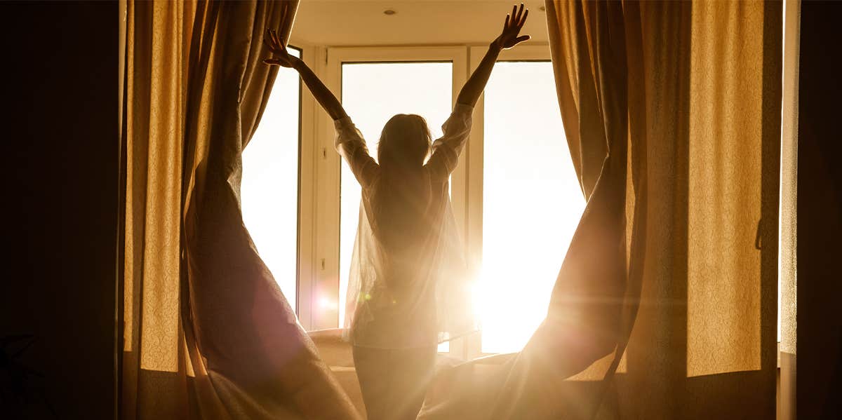 Why You Need To Wake Up And Appreciate The Sunrise woman opening curtains
