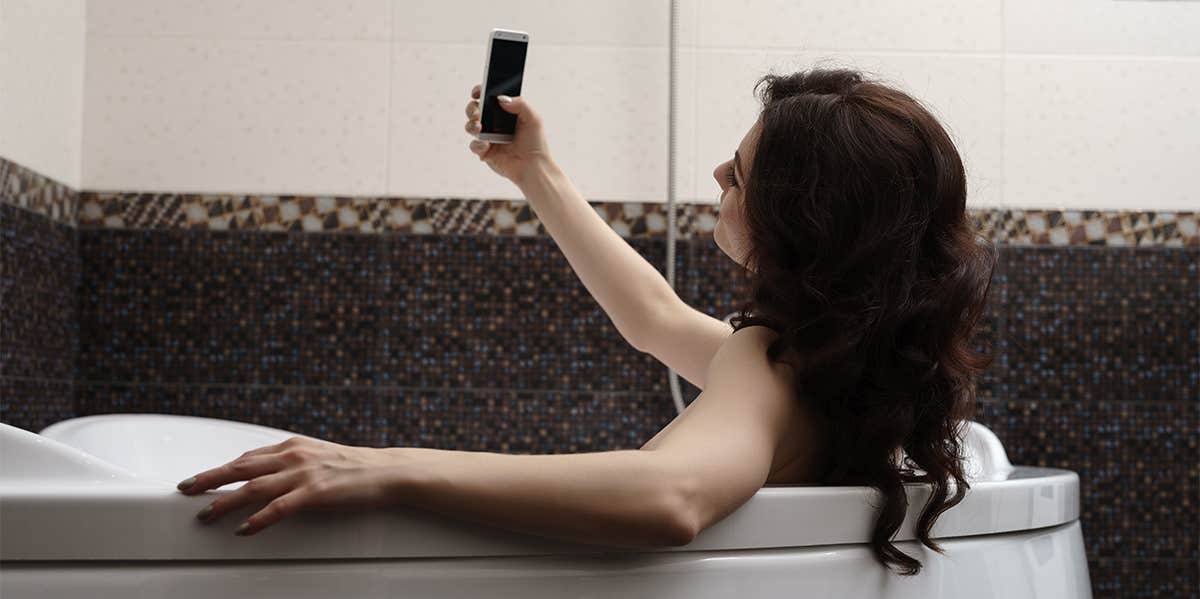 woman taking selfie in bath