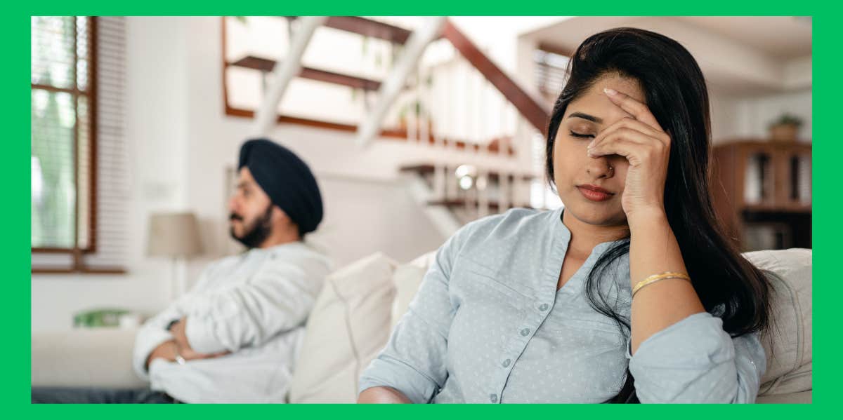 upset wife sitting beside husband on couch