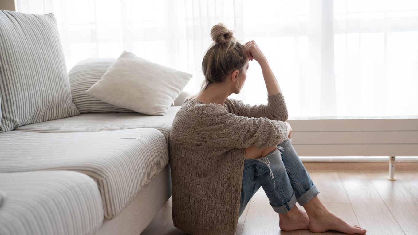 side profile of sad woman sitting on the floor