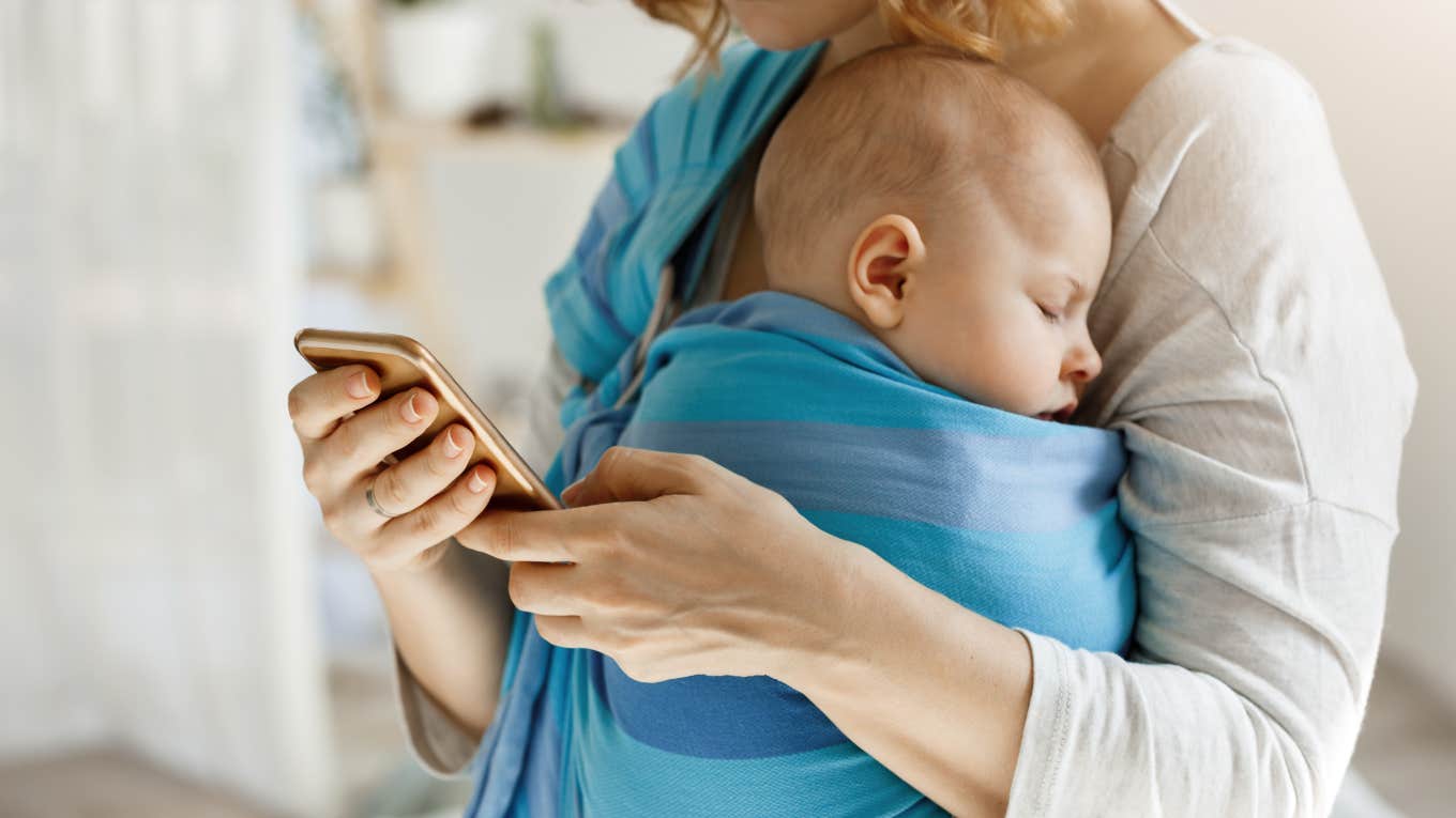 mom carrying baby while on phone