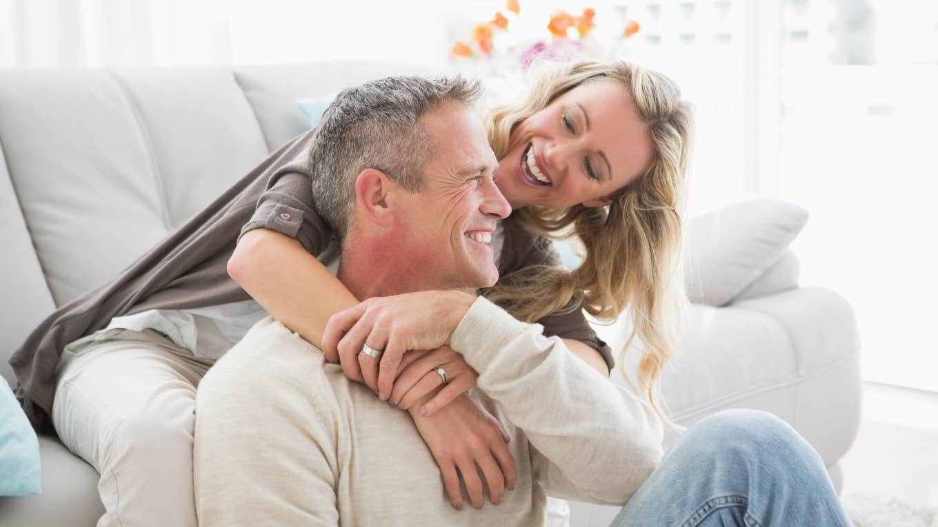 husband and wife cuddling while sitting on the couch