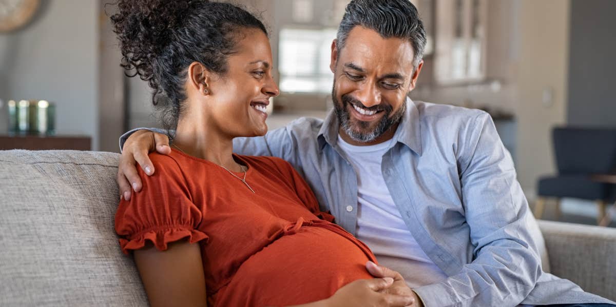 husband caresses the belly of his pregnant wife