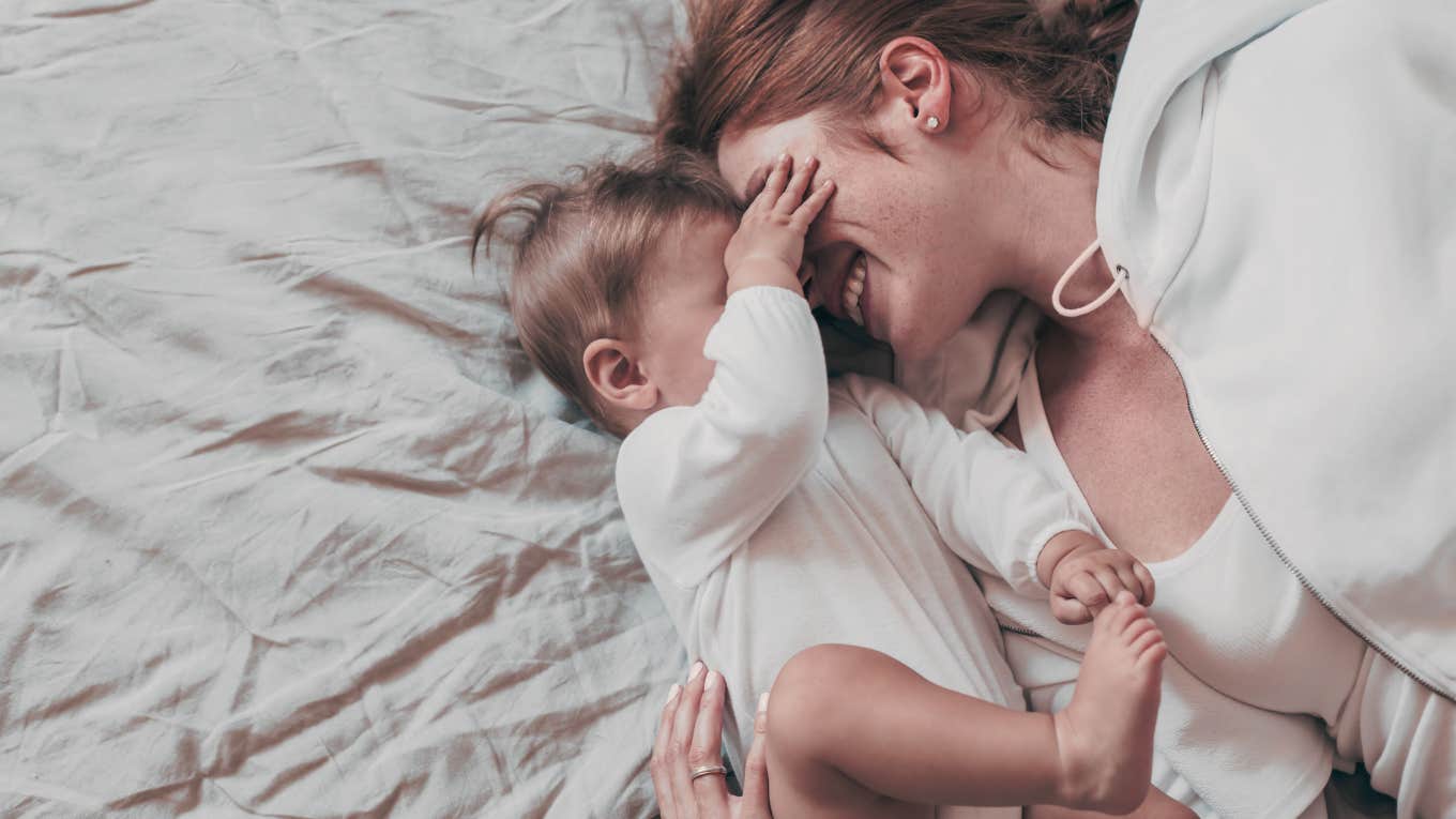 mom cuddling with baby on bed